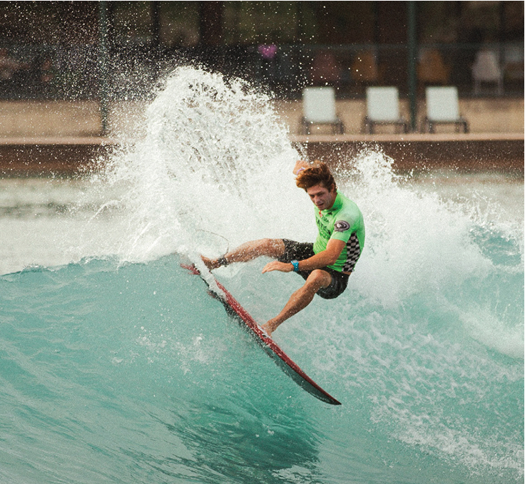 Person riding a wave on surf simulator at resort pool